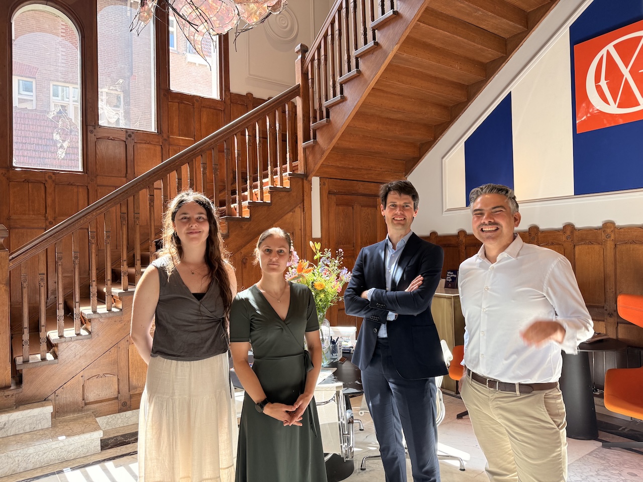 photo-of-Sarah-Oleary-Amber-Willemsen-Mark-Dijkstra-and-Abuzer-van-Leeuwen-standing-in-GMW-lawyers-lobby-discussing-restructuring-in-the-Netherlands-and-what-this-means-for-employees