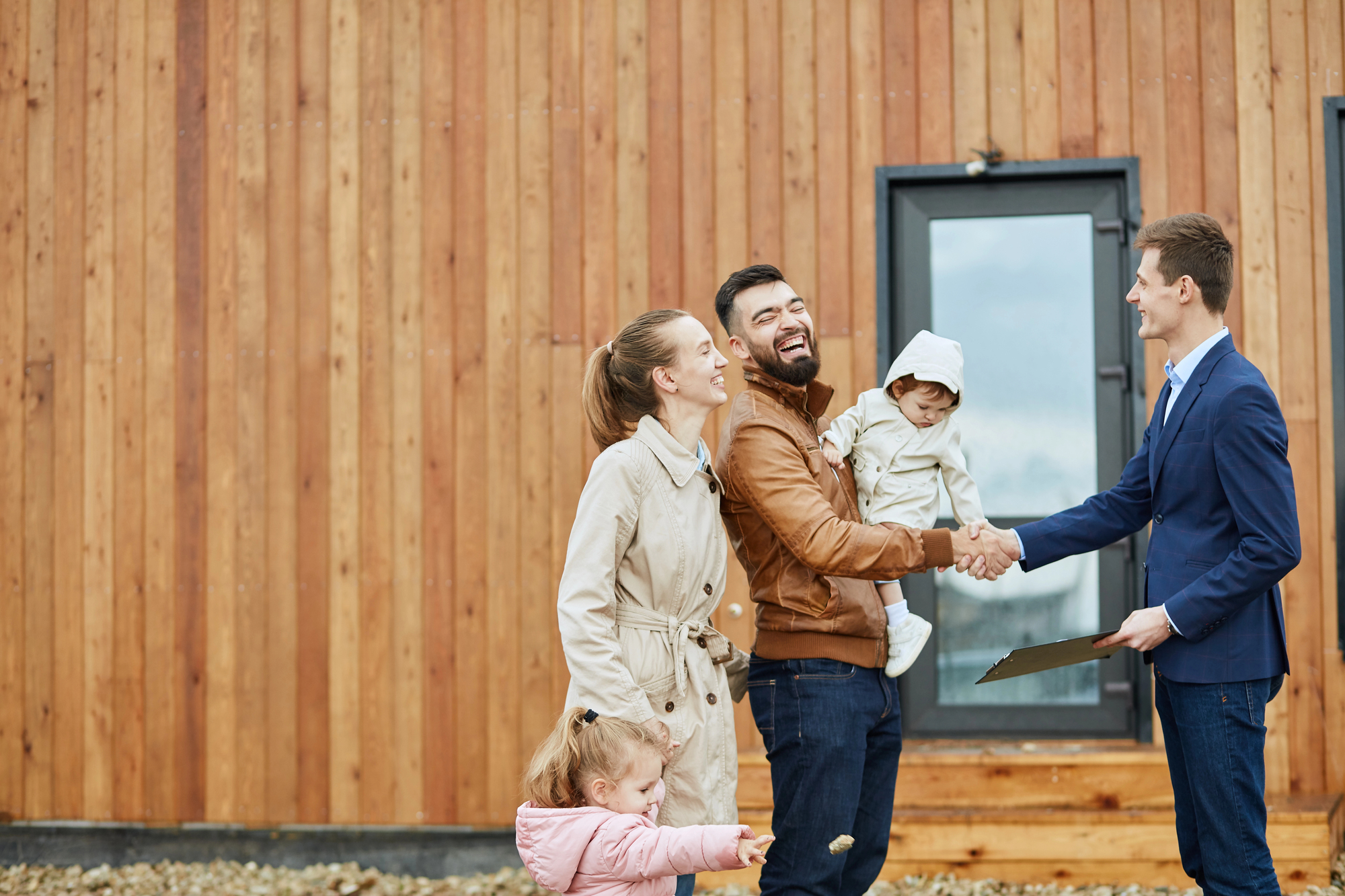 photo-of-young-family-buying-house-in-the-netherlands-shaking-hands-with-realtor