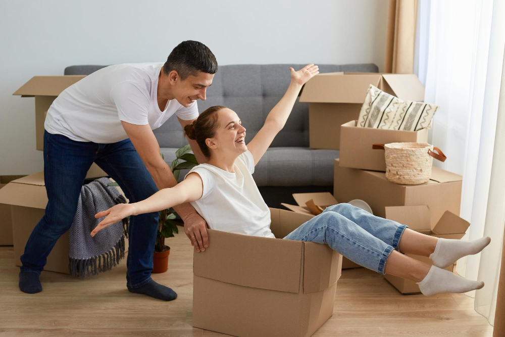 photo-of-couple-pushing-around-boxes-having-fun-after-buying-Dutch-house-using-Dutch-housing-terms