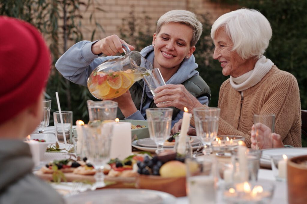 Dutch-woman-pouring-a-drink-for-her-grandmother-outside-on-Wit-Sunday