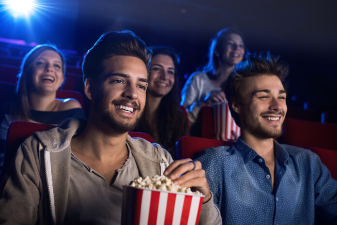 group-of-friends-in-the-cinema-eating-popcorn-and-laughing