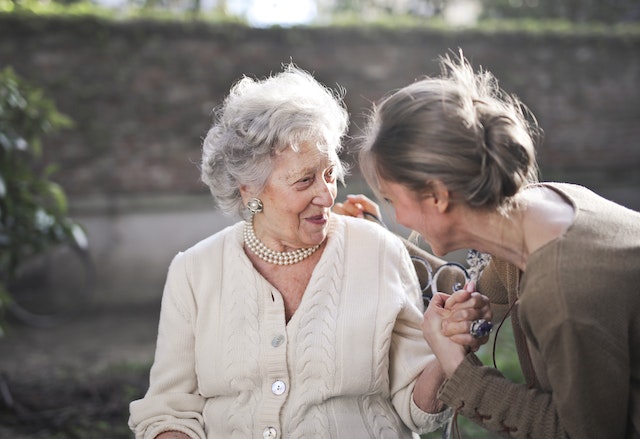 two-elderly-women-sitting-talking