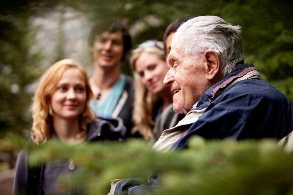 Elderly-man-talking-with-three-young-people