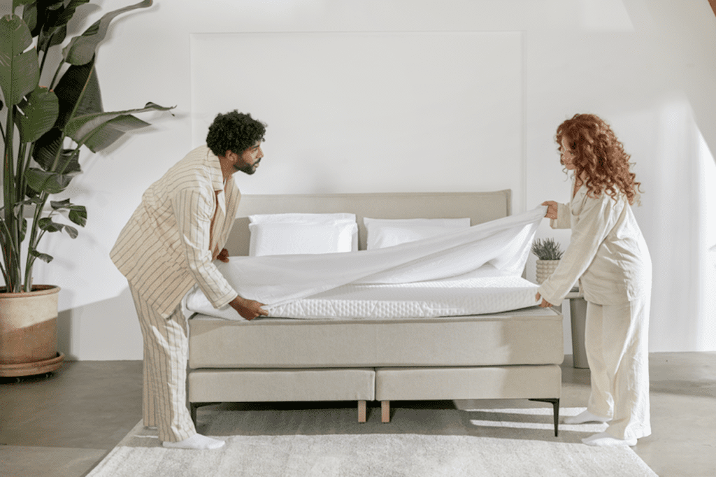 photo-of-couple-putting-comfortable-sheets-on-bed-making-bedroom-cosy