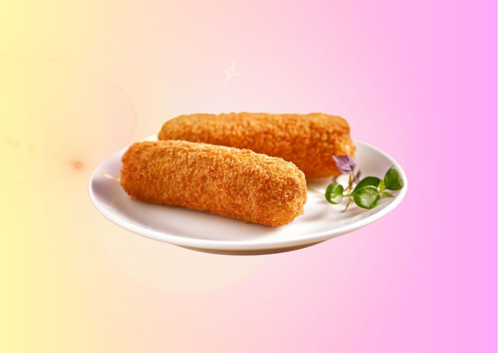 dutch-beef-croquette-on-white-plate-with-sprig-next-to-it-against-yellow-to-lilac-gradient-background