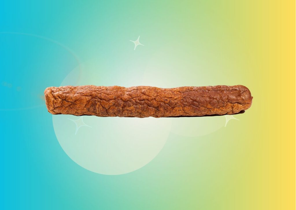 dutch-frikandel-snack-against-gradient-yellow-to-green-background
