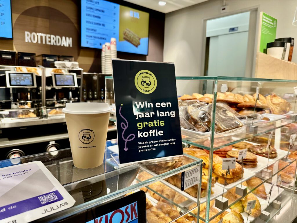 Sign-indicating-chance-to-win-free-coffee-using-reusable-coffee-cups-in-rotterdam-central-station