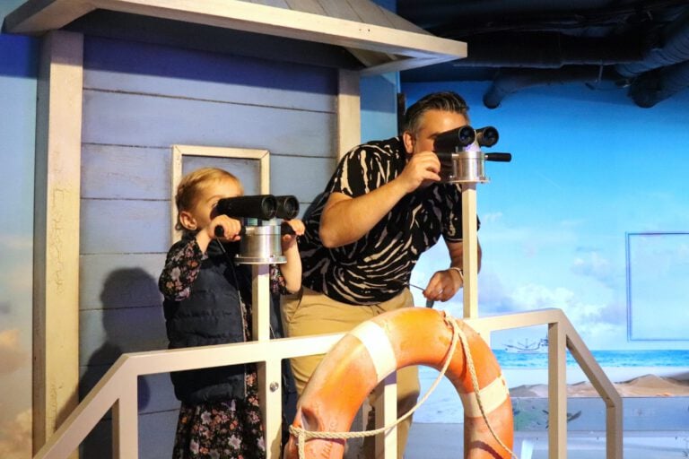 Kid-and-man-looking-through-binoculars-at-beach-at-SEALIFE-Scheveningen-The-Hague