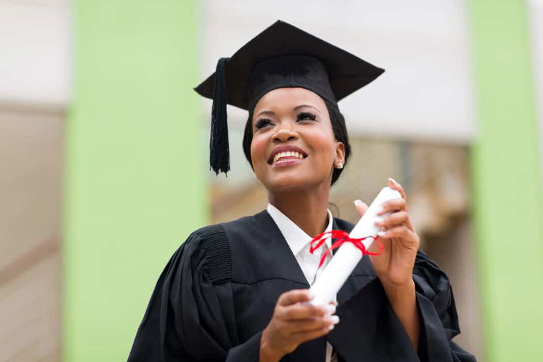 photo-of-an-international-student-wearing-a-cap-and-gown-and-holding-her-degree-certificate-as-she-graduates