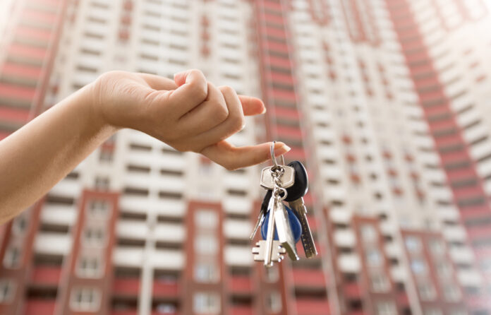 Photo-of-hand-holding-keys-in-front-of-building-Netherlands