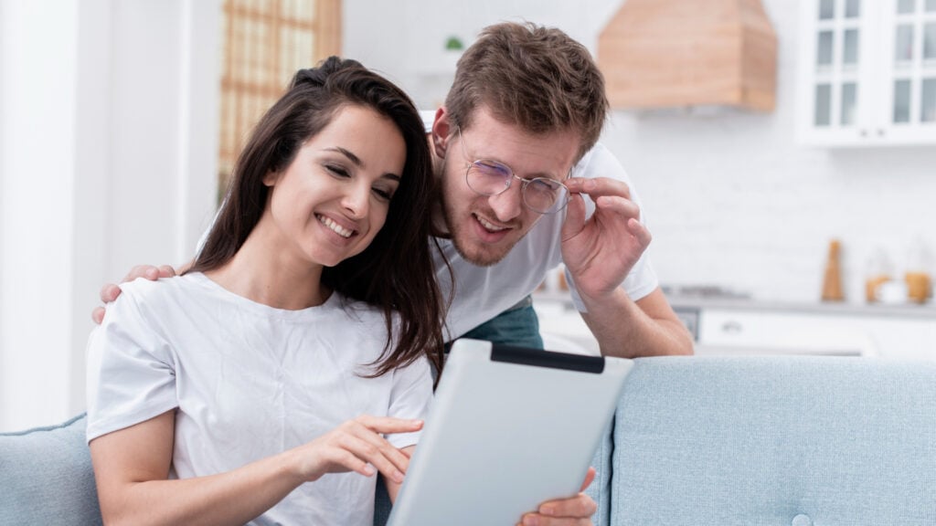 photo-of-man-squinting-at-screen-girlfriend-is-holding-looking-at-bid-calculation-while-bidding-on-house-in-the-Netherlands