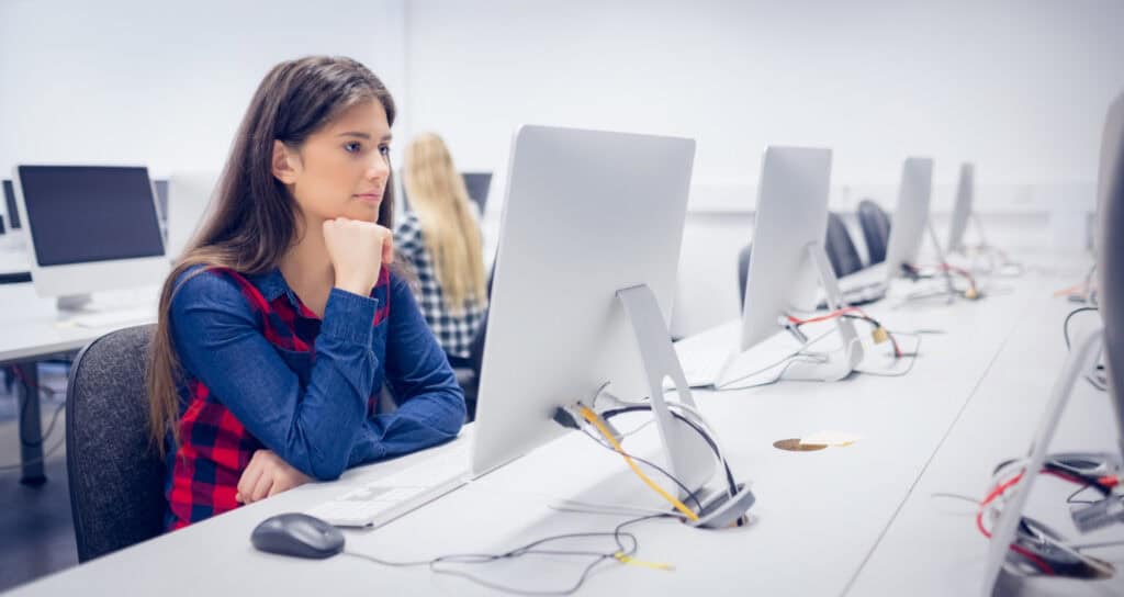 photo-of-woman-sitting-in-inburgering-test-centre-looking-at-computer-screen