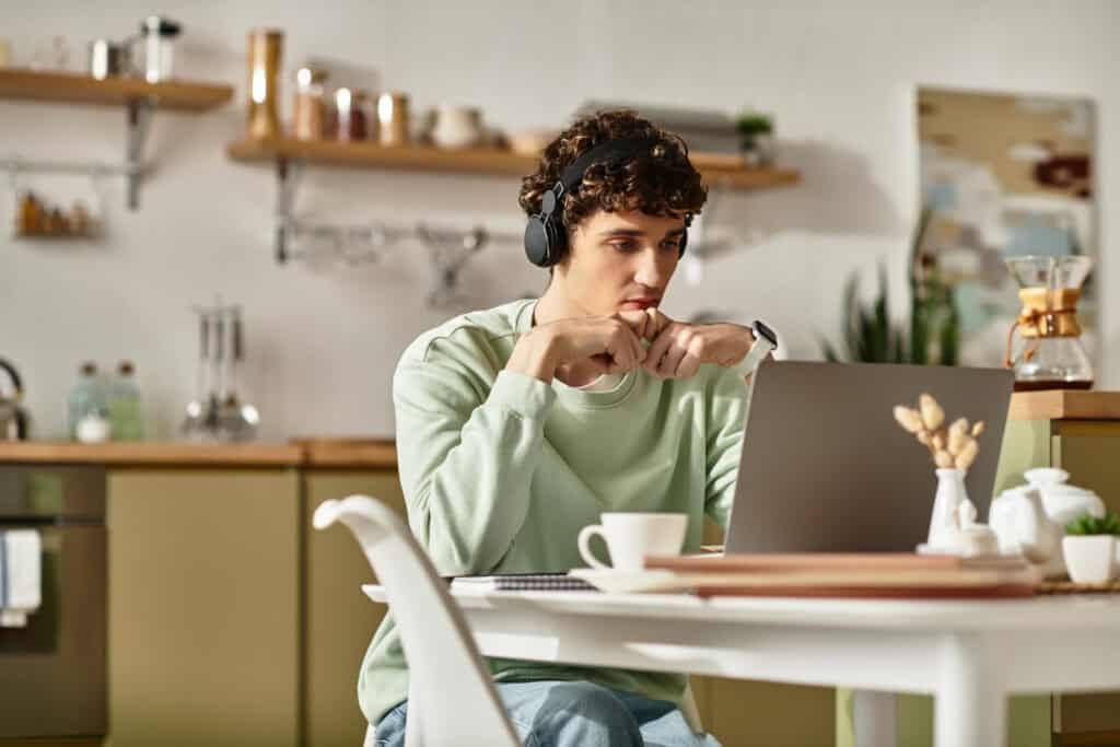 photo-of-man-sitting-at-desk-in-kitchen-looking-at-laptop-while-working-in-the-Netherlands-without-Dutch-employment-contract