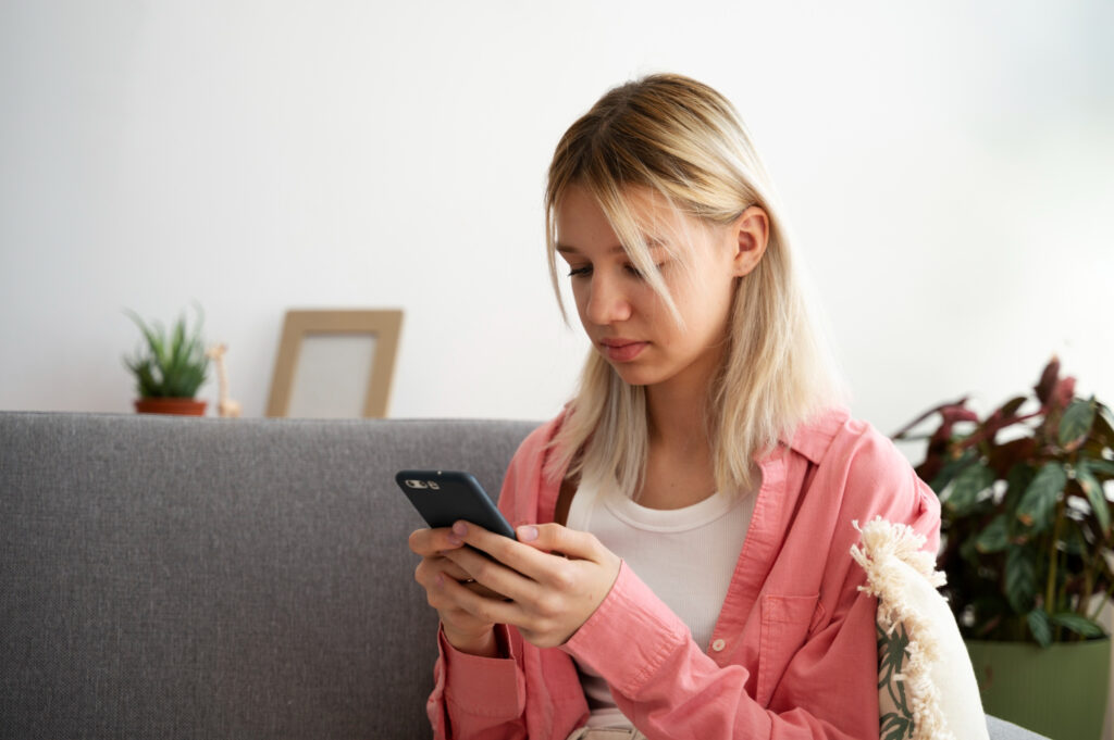 photo-of-woman-on-couch-looking-down-at-phone-notifying-Dutch-employer-about-her-workplace-burnout