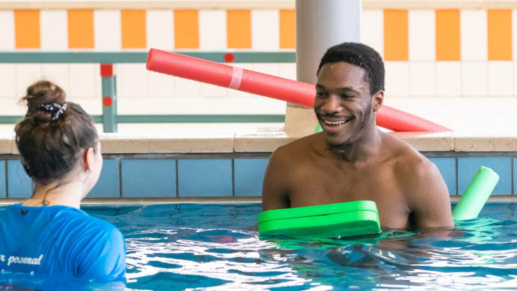 Photo-of-man-learning-how-to-swim-with-your-personal-swim-coach-staff-member-in-pool