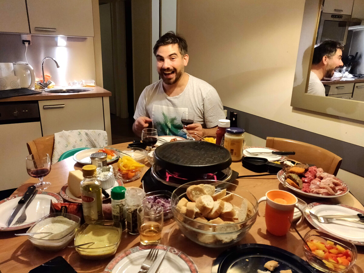 Man-sitting-at-table-with-gourmet-grill-and-glass-of-wine-in-hand