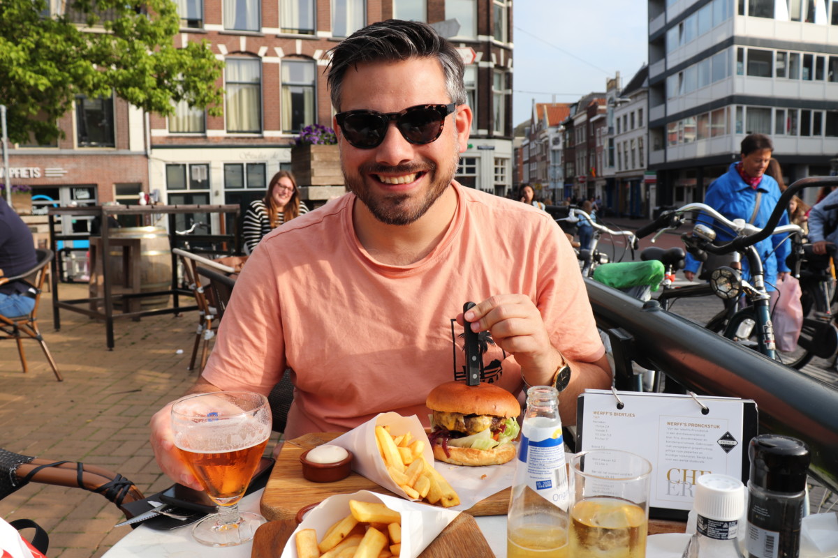 Photo-of-man-eating-burger-at-restaurant-Leiden