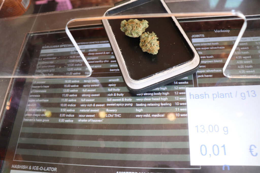 two buds of weed on a scale and price list in Coffeeshop Amsterdam
