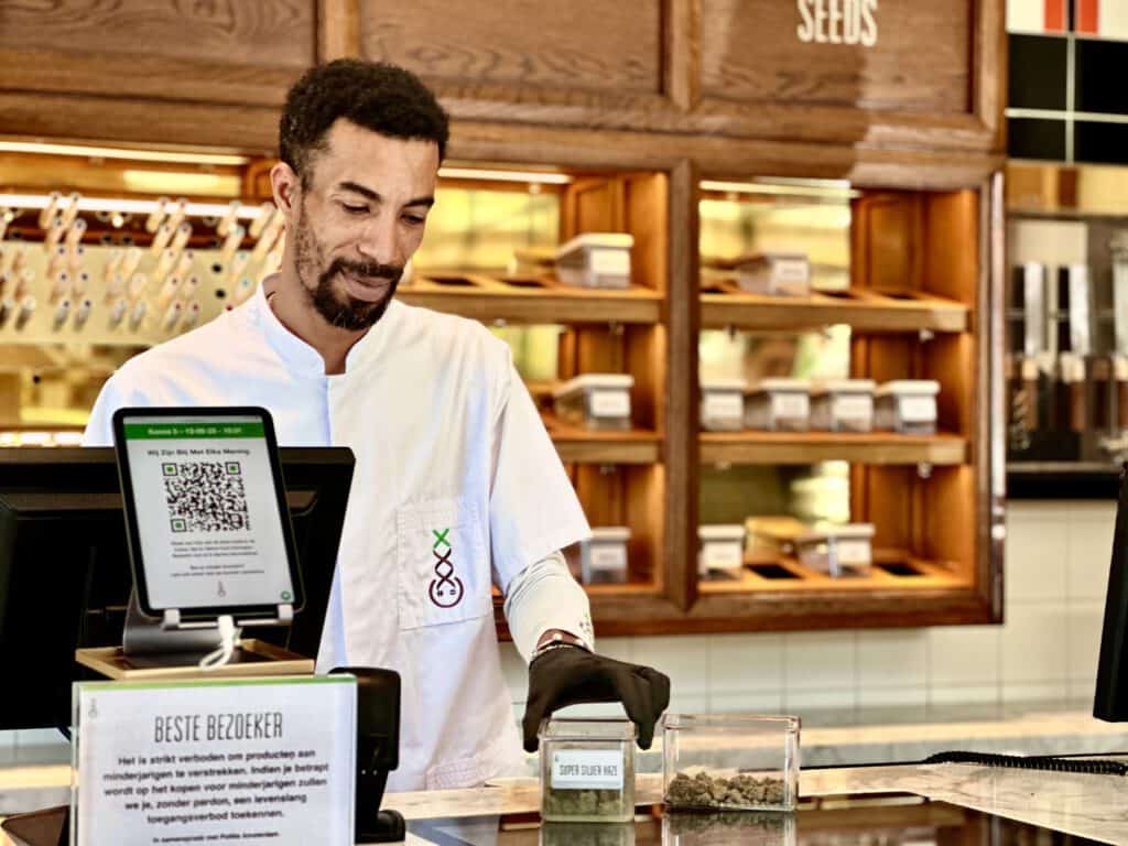 photo-of-handsome-budtender-putting-lid-on-weed-container-at-coffeeshop-in-amsterdam