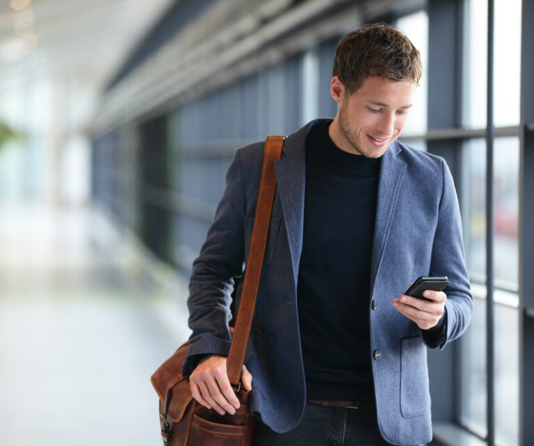 Photo-of-man-smiling-down-at-phone-investing-in-IPOs