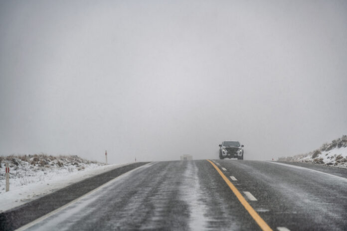 photo-of-extremely-icy-roads-with-a-car-driving-cautiously