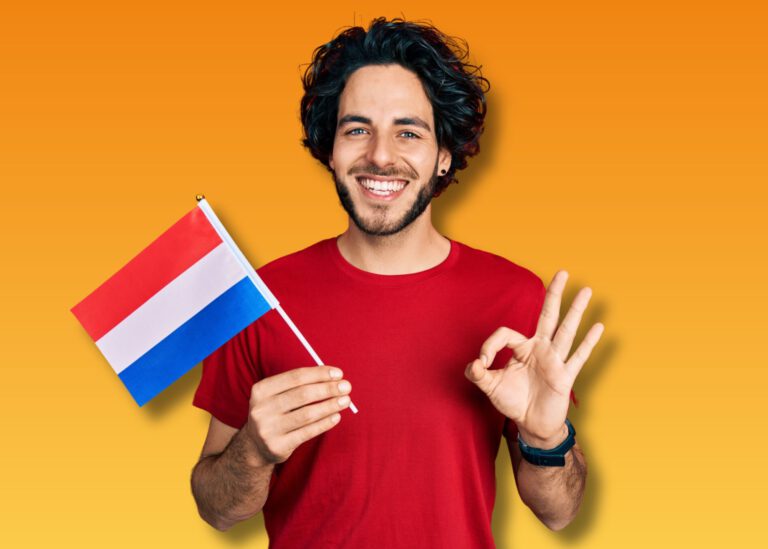 photo-of-smiling-man-holding-dutch-flag-and-making-ok-symbol-after-passing-dutch-inburgering-exams