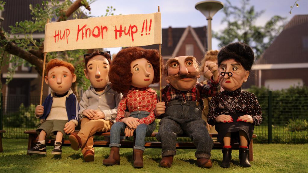 Clay-puppet-family-sitting-with-banner-from-Dutch-movie-Knor