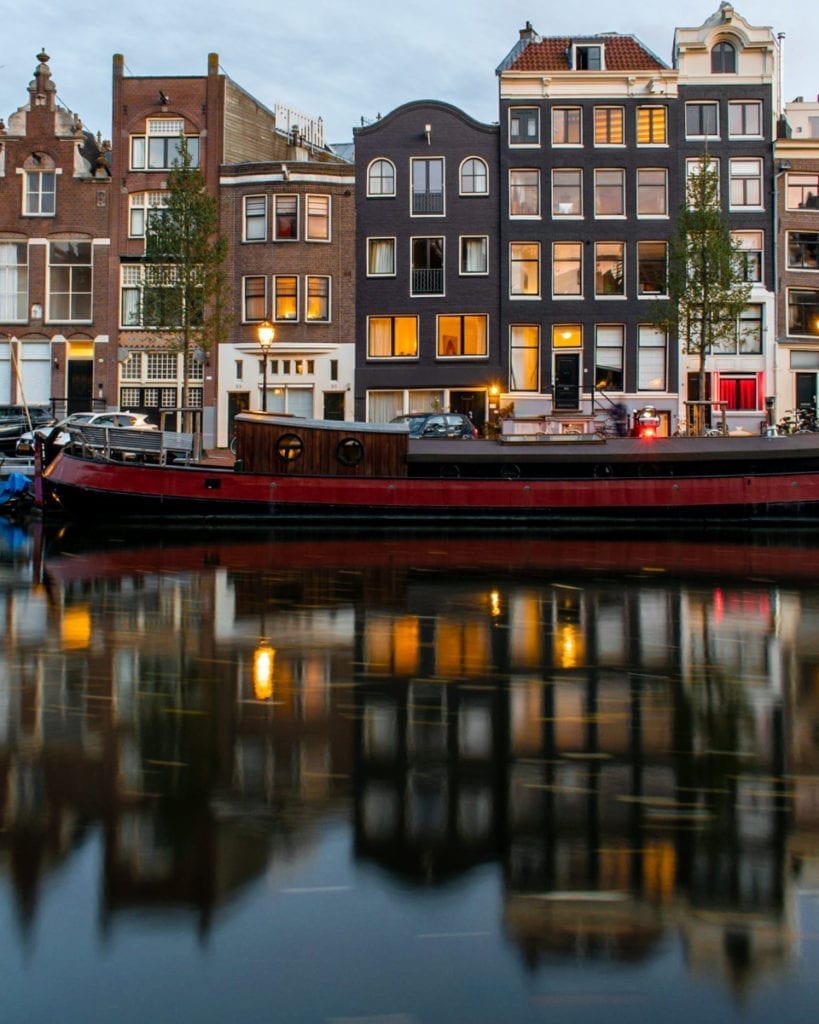 boat-sailing-in-front-of-canal-houses-amsterdam