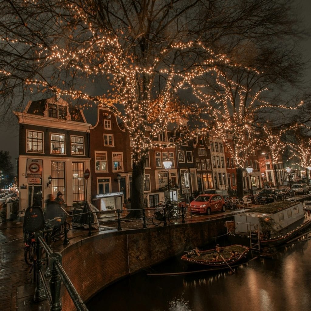 fairy-lights-on-trees-by-canal-houses-amsterdam