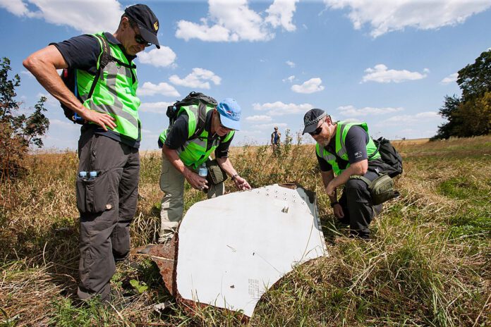 Photo-of-men-investigating-wreckage-MH17-downing