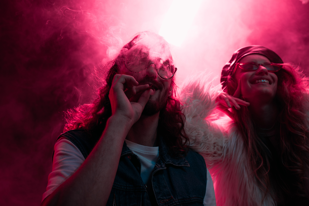 Man-and-woman-smoking-weed-inside-an-Amsterdam-club-standing-in-pink-light