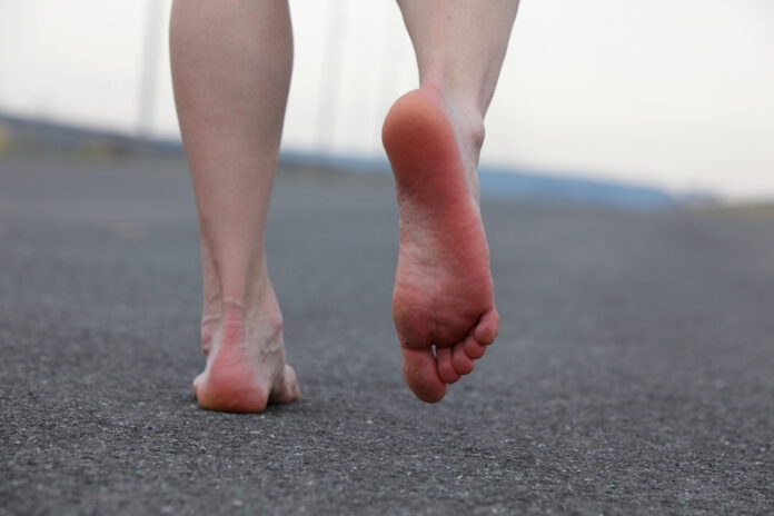 Man-walking-barefoot-on-concrete