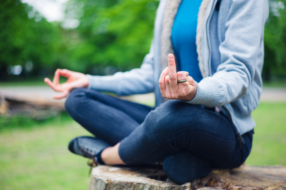 woman-sitting-cross-legged-in-meditation-with-ironic-middle-finger-hand-gesture-after-receiving-dutch-pick-up-lines