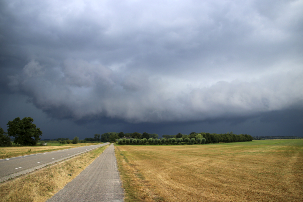 Dark-stormy-clouds-over-flat-dutch-landscape-with-mowed-fields