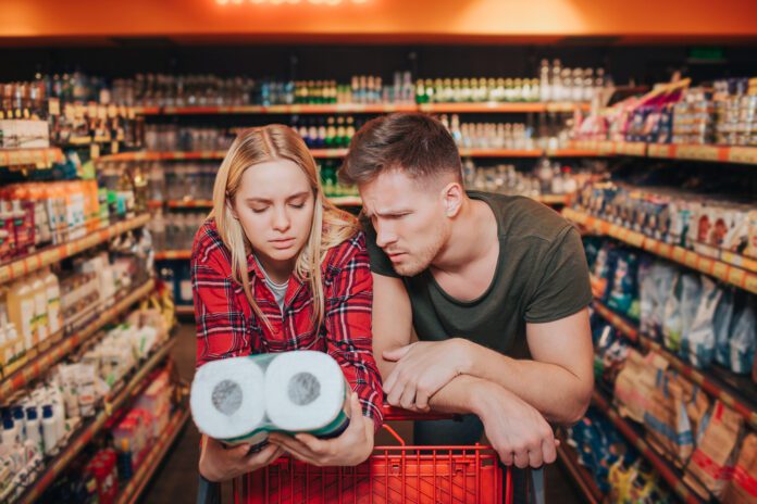 photo-of-couple-looking-at-straw-toilet-paper-with-confused-expression-in-supermarket