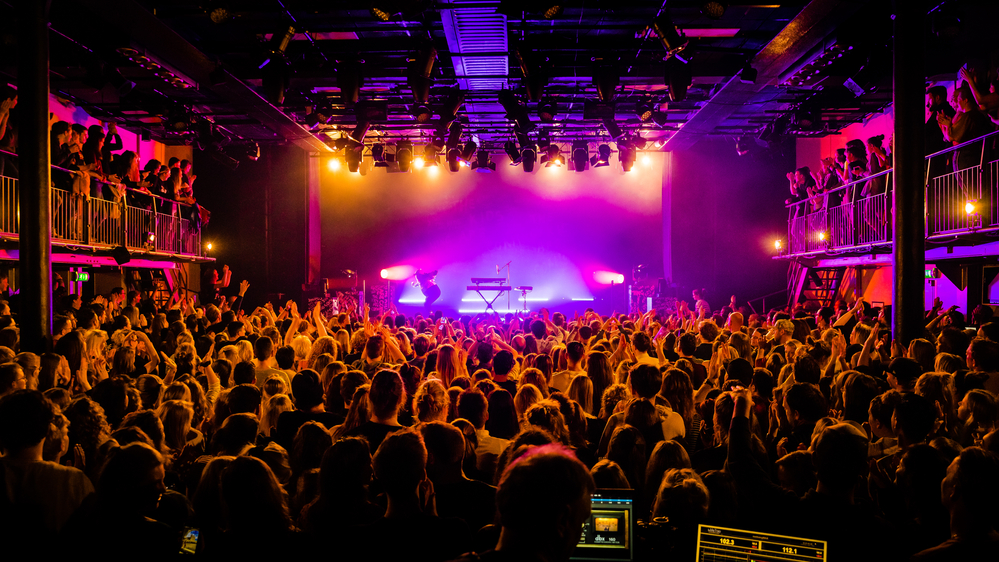 broad-angle-photo-of-party-in-club-melkweg-with-purple-light-play