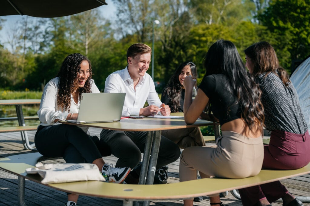 students-sitting-together-at-a-picnic-table-to-work-at-nyenrode-business-university-in-the-netherlands