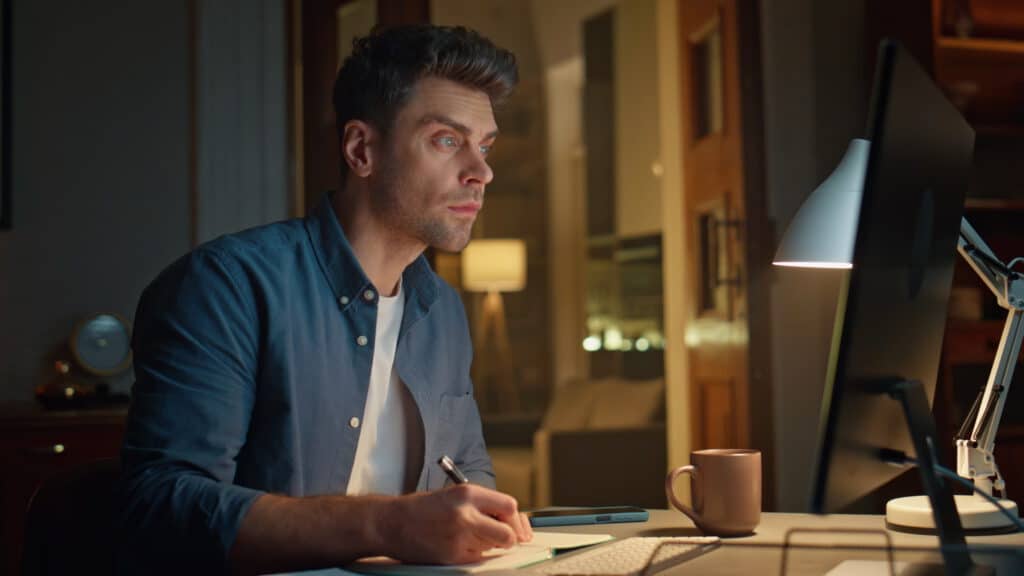 photo-of-man-taking-online-Dutch-course-sitting-at-desk-during-evening