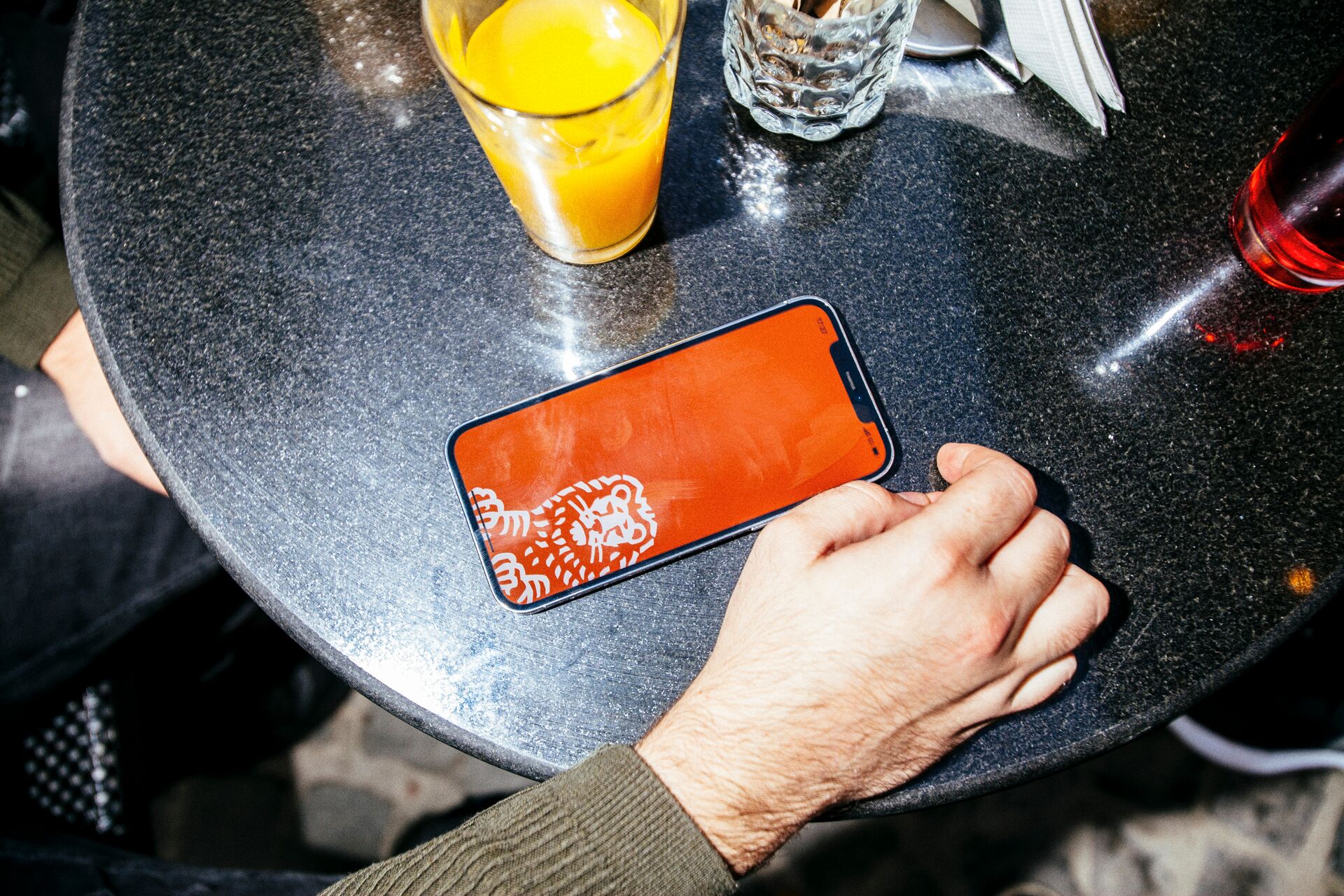 Overhead-view-of-outside-restaurant-table-with-a-drink-and-a-phone-opening-the-ING-app-to-send-a-payment-request