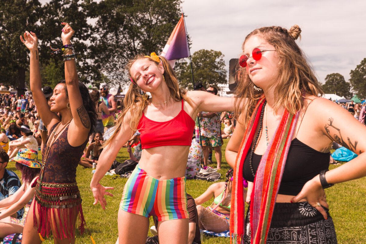 photo-of-three-women-at-a-festival-dancing-and-having-fun