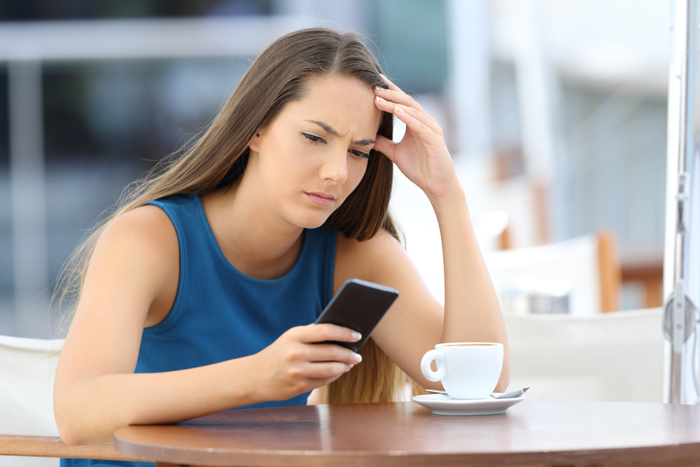 Woman-looking-disappointed-at-her-phone
