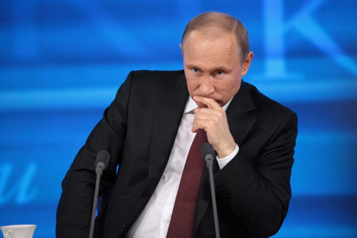 Putin-sitting-in-a-conference-thinking