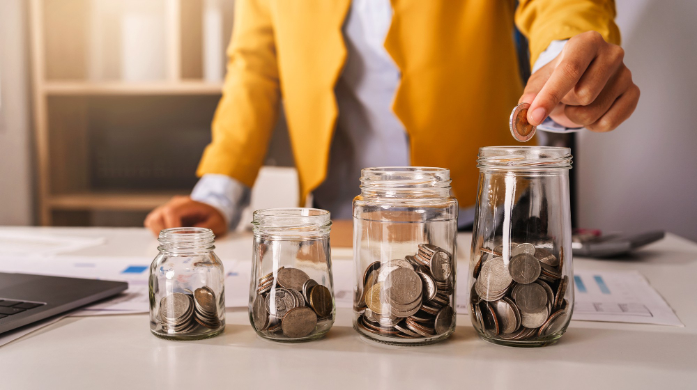 Woman-adding-coins-to-jars-using-Raisin-financial-services