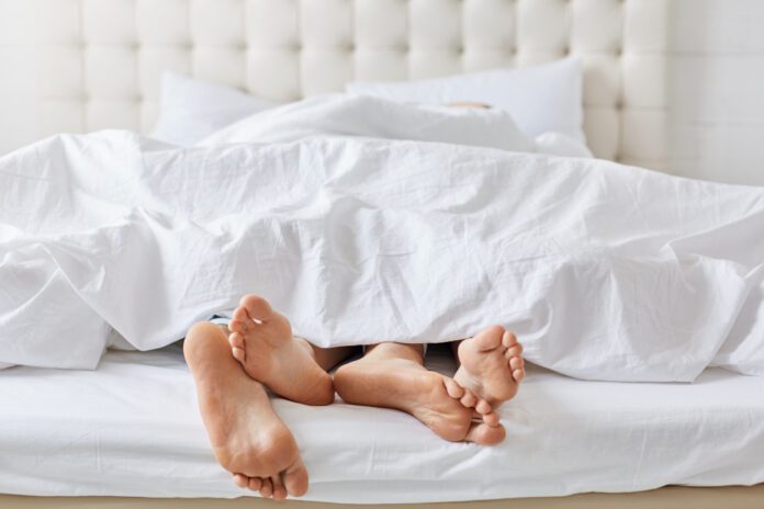 photo-of-feet-coming-out-of-sheets-couple-in-bed