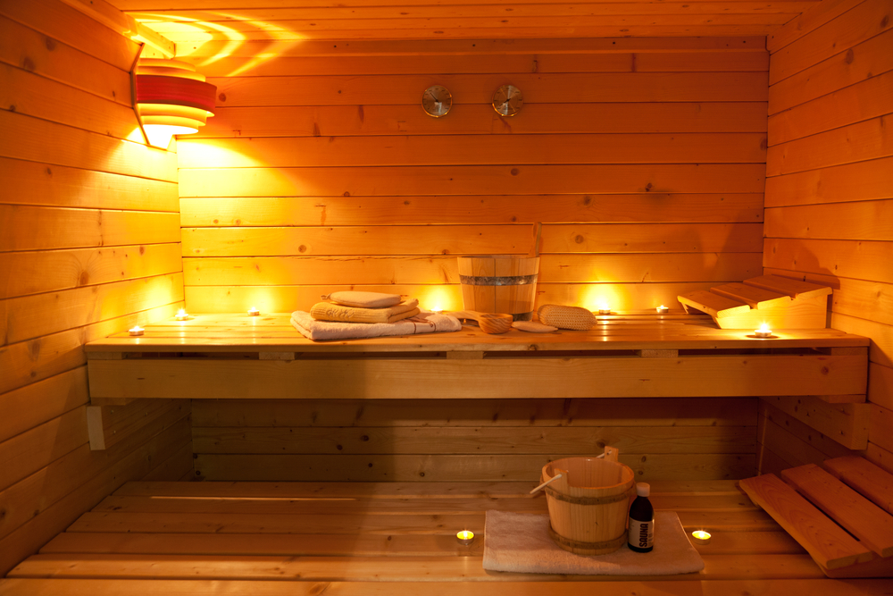 Warmly-lit-interior-of-wooden-sauna-in-the-netherlands-with-buckets-and-laddles