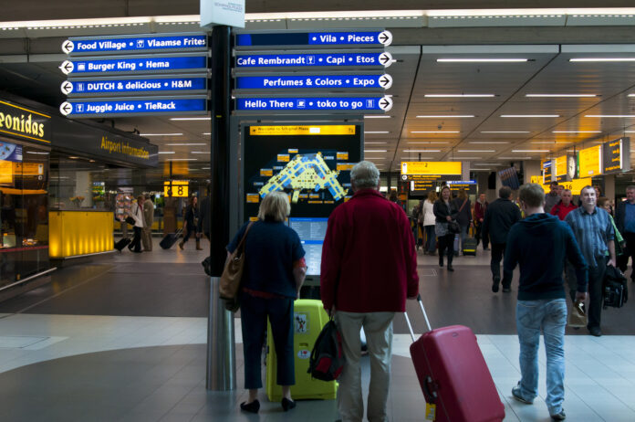 Travellers-walking-with-luggage-through-Schiphol-airport-the-Netherlands