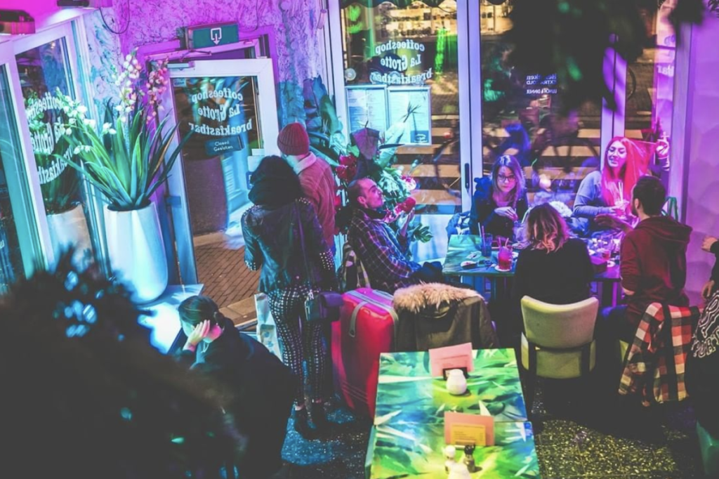 Group-of-people-sitting-inside-smokers-bar-la-grotte-in-Amsterdam-with-purple-light-play