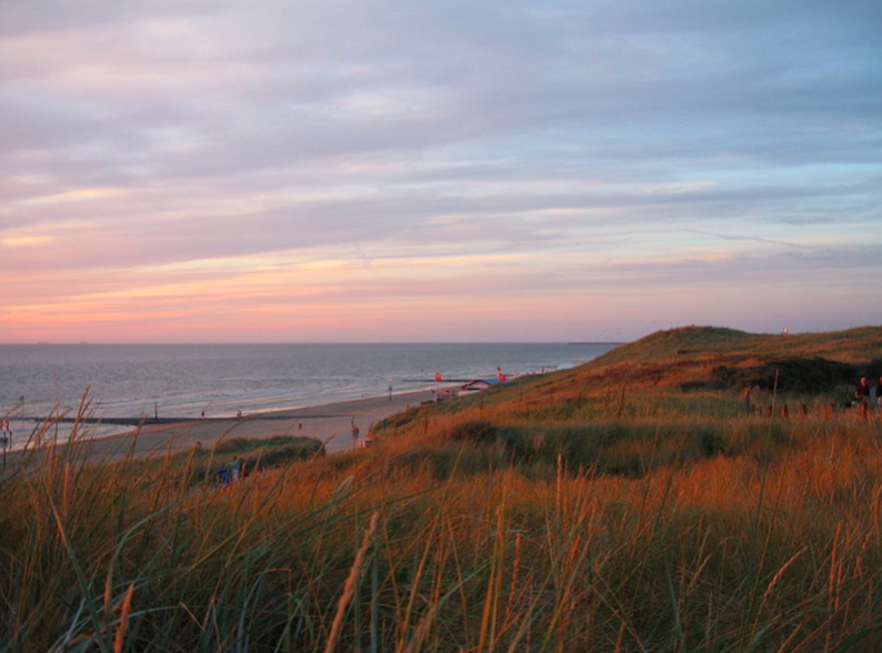 Image-of-sun-setting-over-dunes-in-Kijkduinen-beach