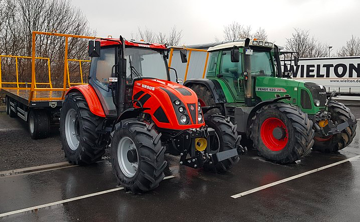 photo-of-one-red-tractor-and-one-green-tractor-parkt-next-to-one-another