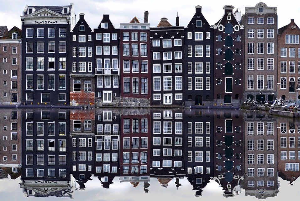 photo-of-a-row-of-amsterdam-canal-houses-lining-a-canal-and-reflecting-in-the-water